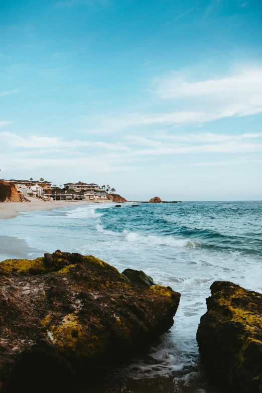 an empty beach with lots of rocks near the ocean