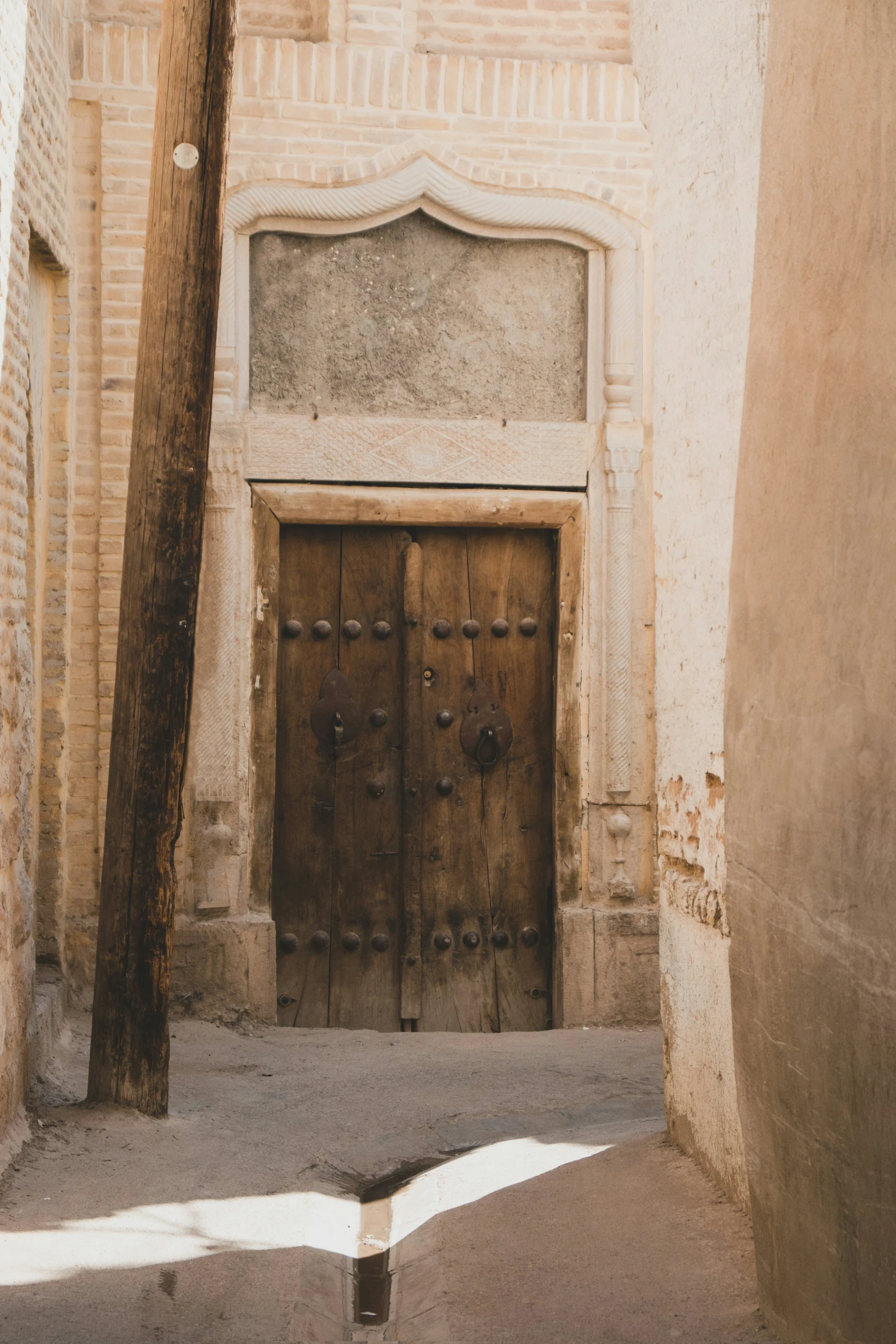 a wooden door in the corner of a narrow street