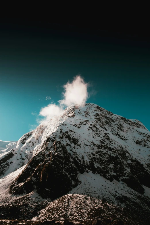 snow covered mountain under a dark sky in the mountains