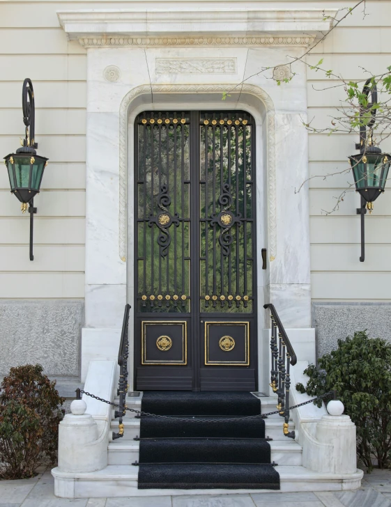 black door with gold accents and two green lights