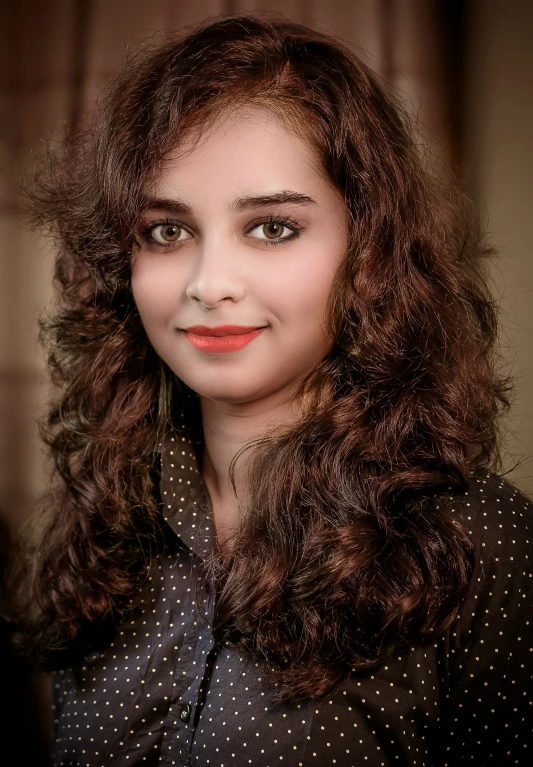 a lady with brown curly hair smiles at the camera