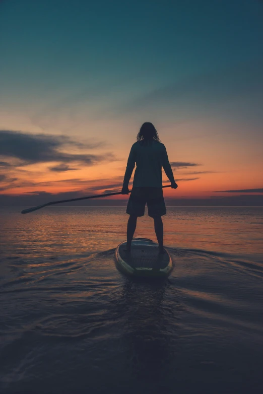 a woman standing on a surf board in the ocean