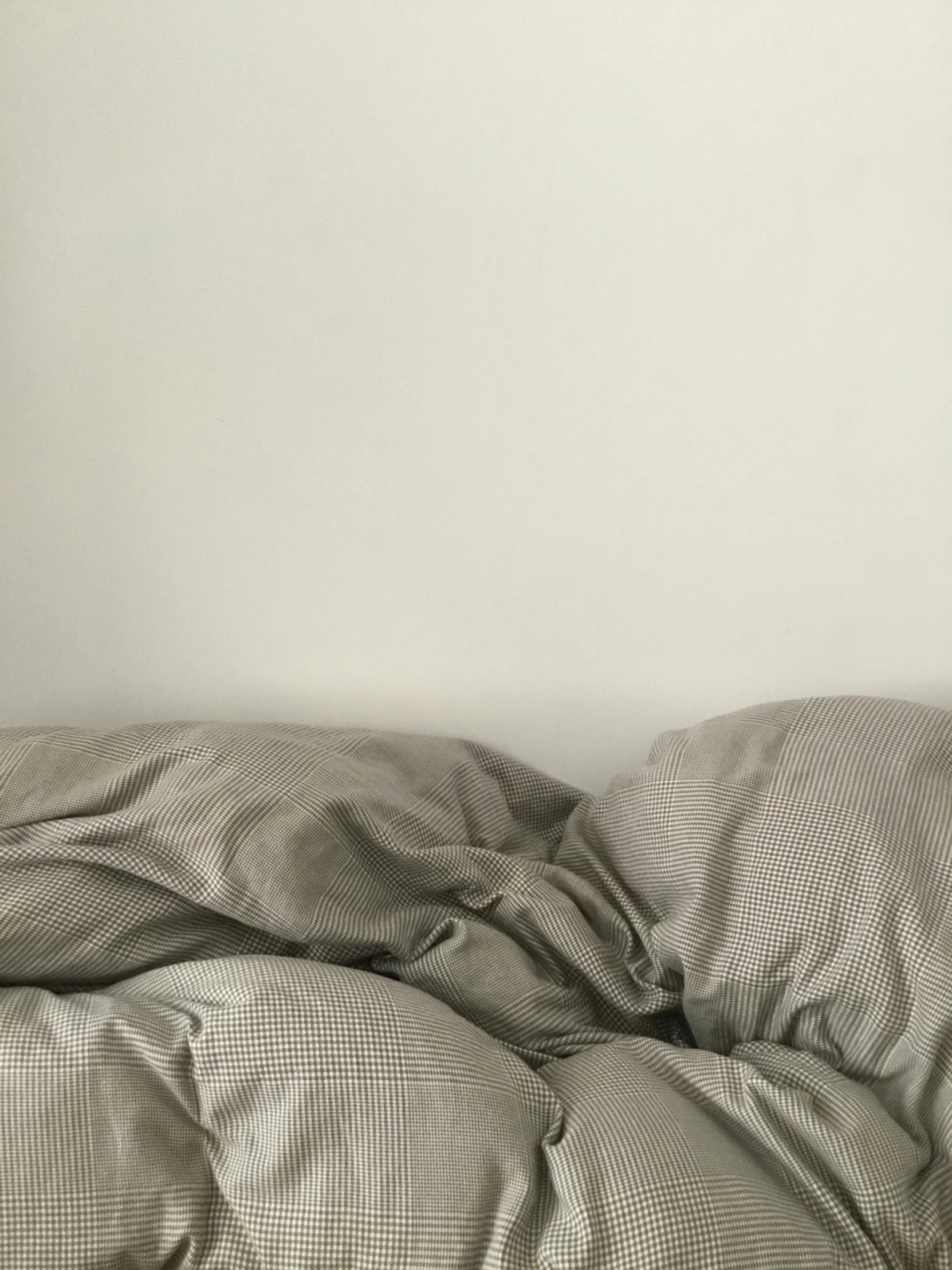 a bed covered with white sheets in a bedroom