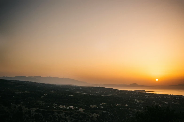 the sun is setting on a beautiful island with mountains in the background