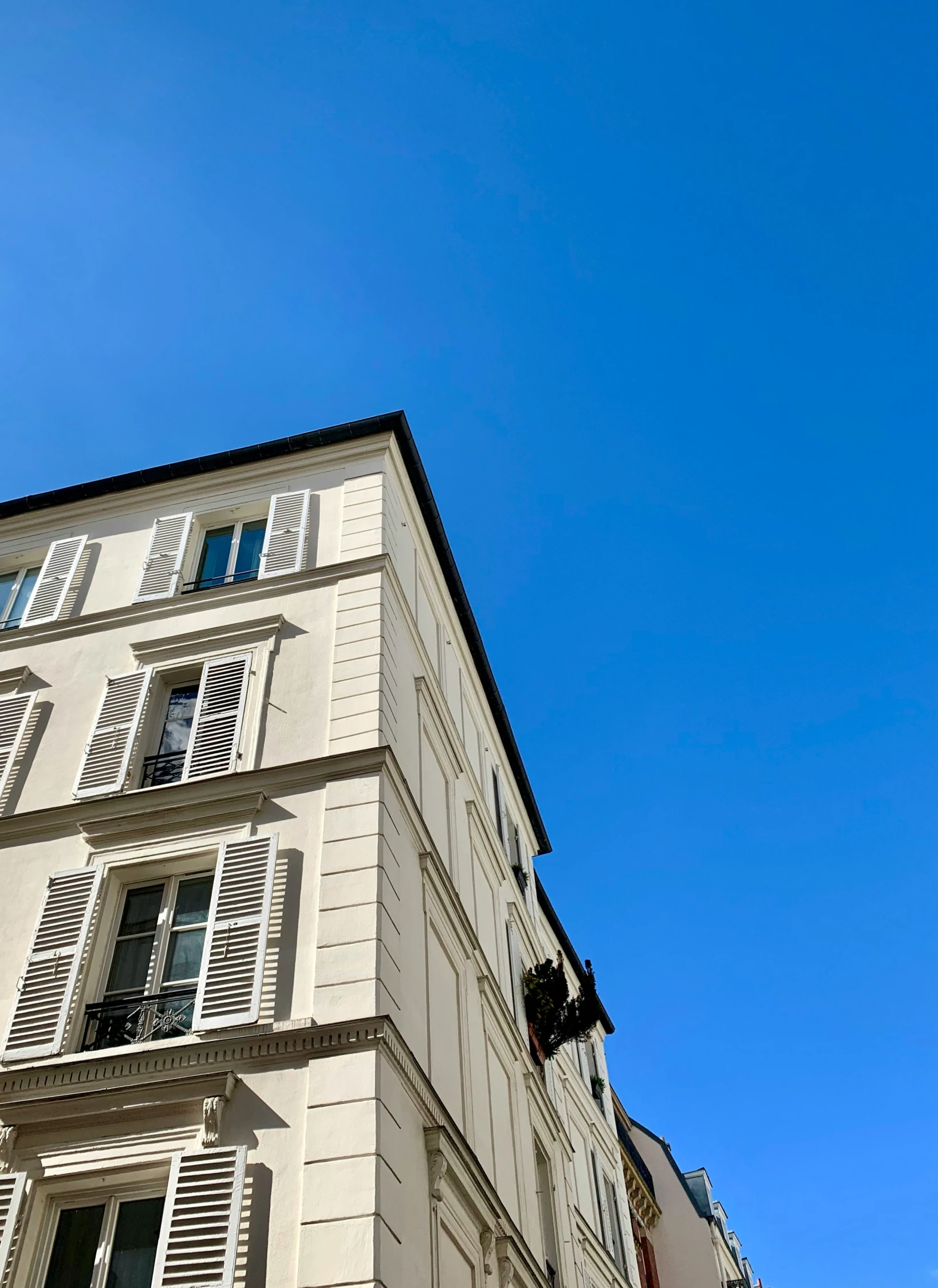 the windows of a large white building with shutters on it