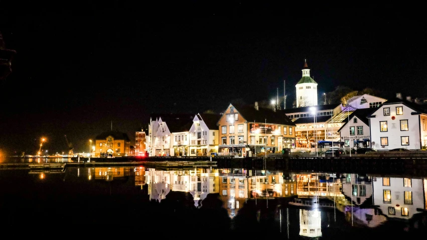 the buildings reflect in a still water area