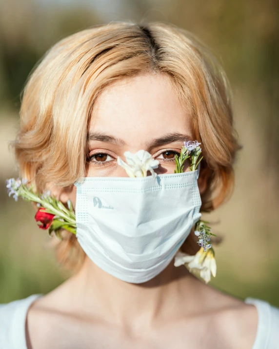 a woman with flowers in her hair and a face mask