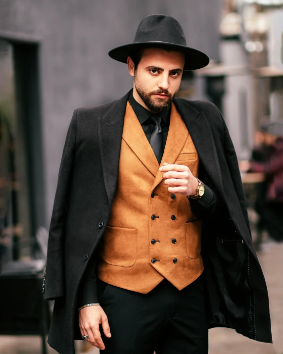 a man with a mustache in a brown suit and a black hat