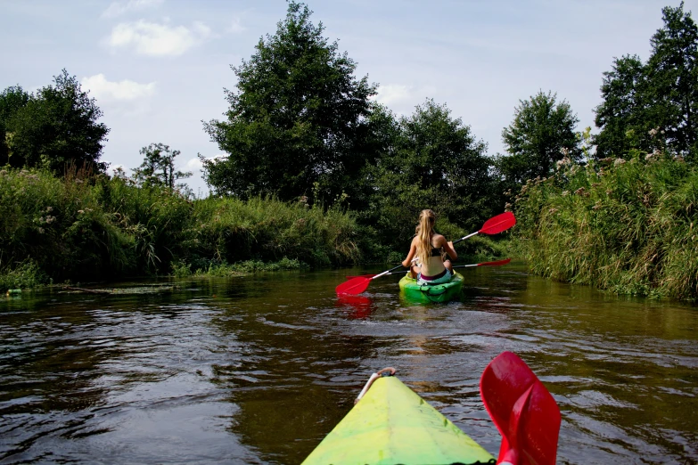 a girl in a kayak paddles down a river