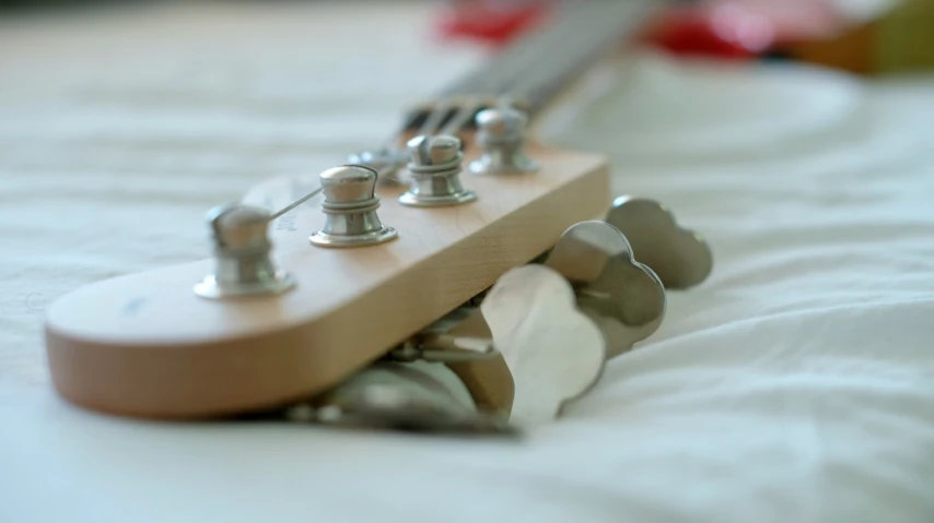 an electric guitar sitting on a white bed