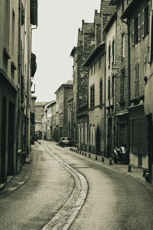 a narrow cobblestone street in old town with some cars