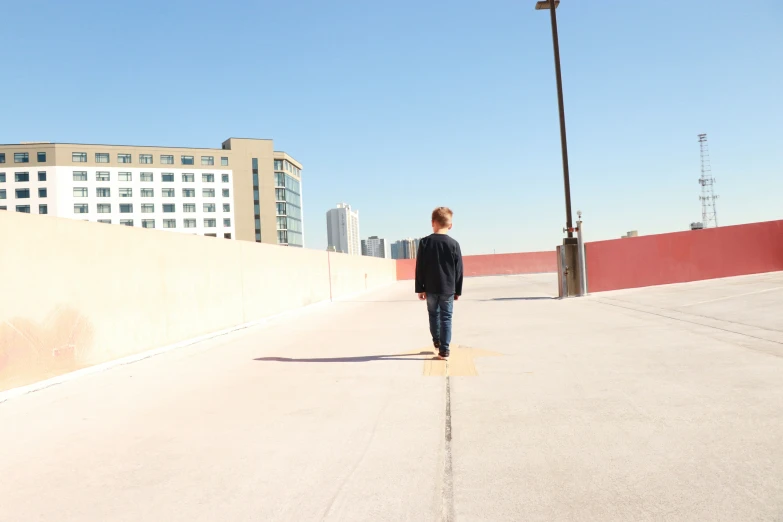 a person walks down an empty walkway in front of a building