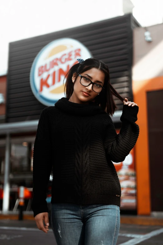 the woman is walking down the street in front of the burger king