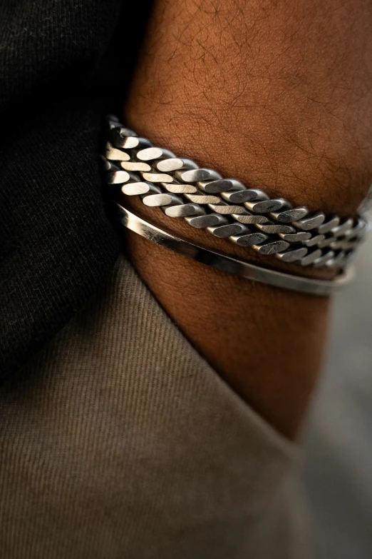 silver celet with black beads on someones arm