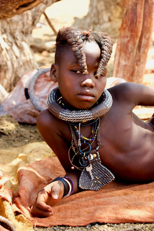 a child with two necklaces on laying down