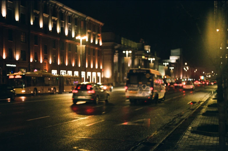 a city street filled with lots of traffic next to tall buildings