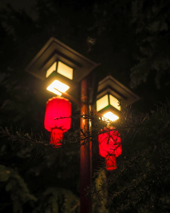 three bright red lanterns are lit up in the dark