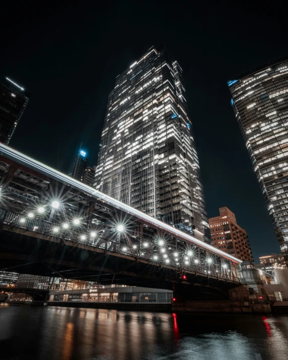 there are tall buildings near the water at night