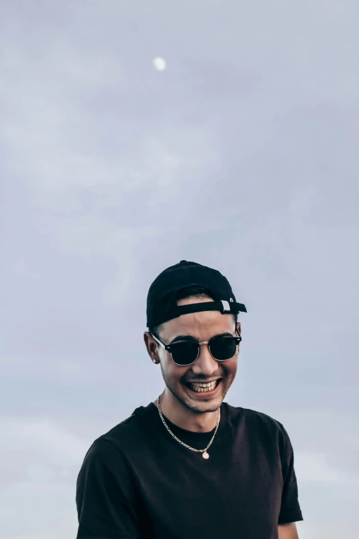 a man wearing sunglasses is smiling in the sun