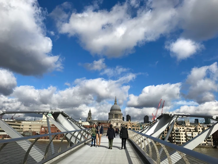 two people are standing on a bridge that's overlooking the city