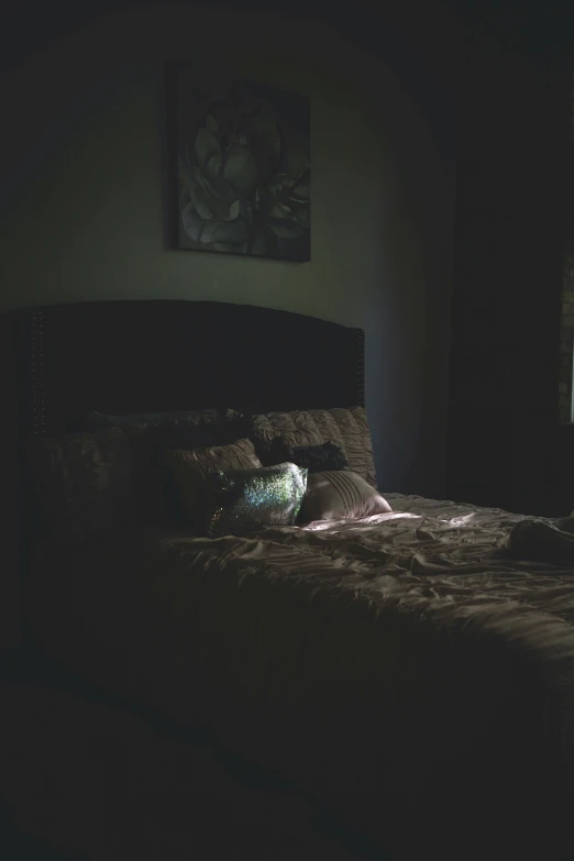 a lamp shines on an empty bed in a bedroom