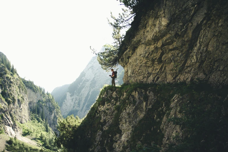 some men are standing on the side of a steep mountain