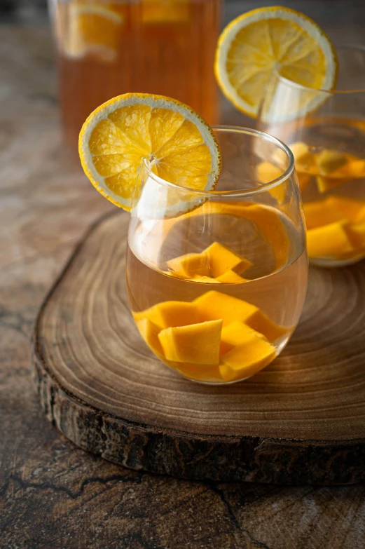 two glasses filled with liquid with sliced fruit