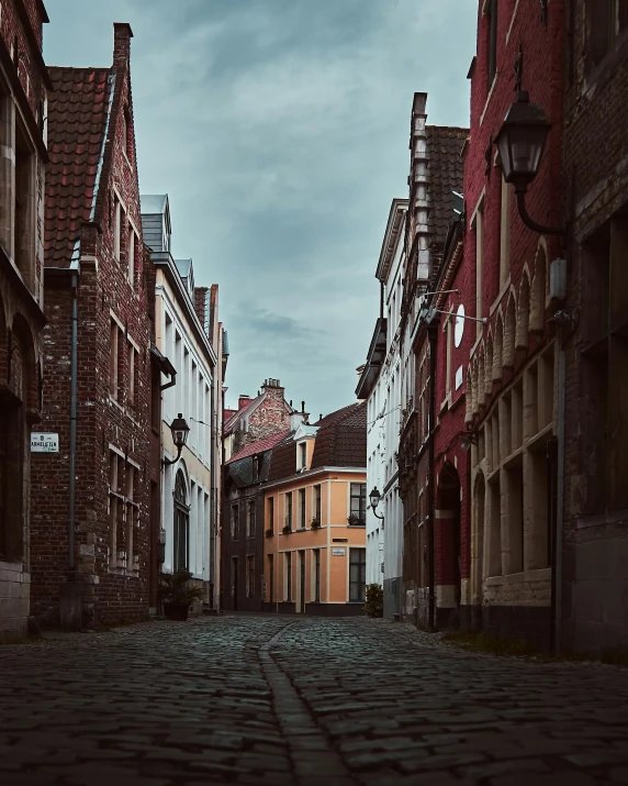 an old, narrow cobblestone street between two large brick buildings