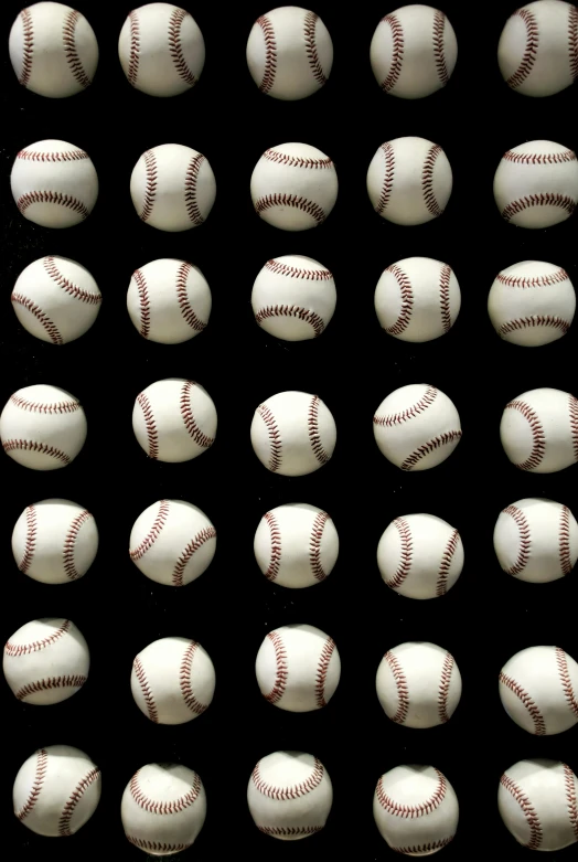 various baseballs and batter's mitts arranged on a black background
