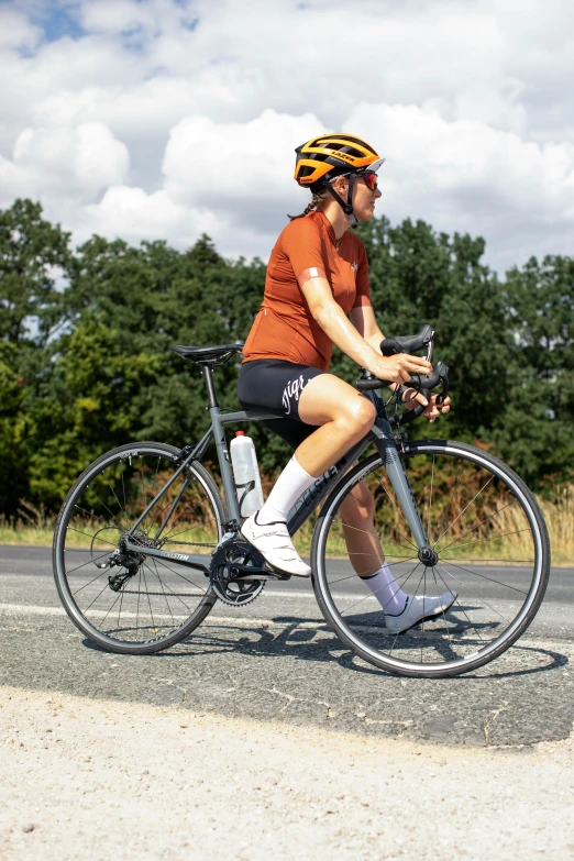 a person wearing helmet rides a bicycle down the road