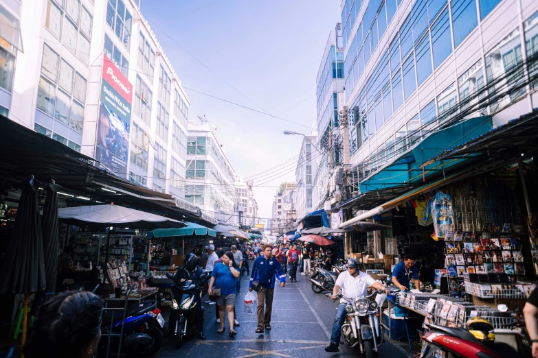 people walk along the road near a group of shops