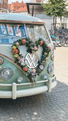 a vw bus is decorated with a heart wreath