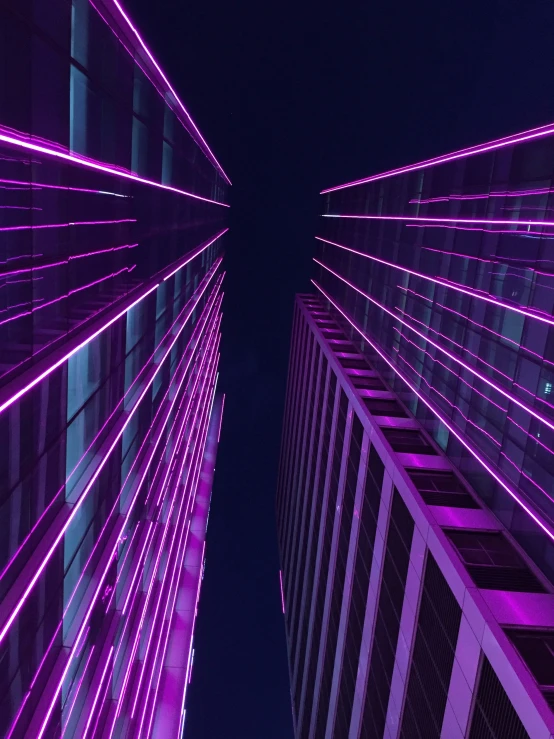 purple colored lights fill the night sky between two buildings