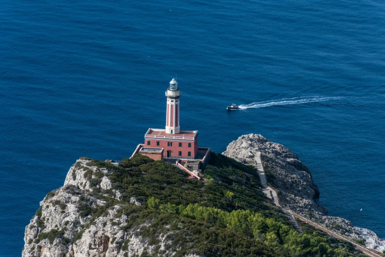 a boat sailing on the ocean behind a lighthouse