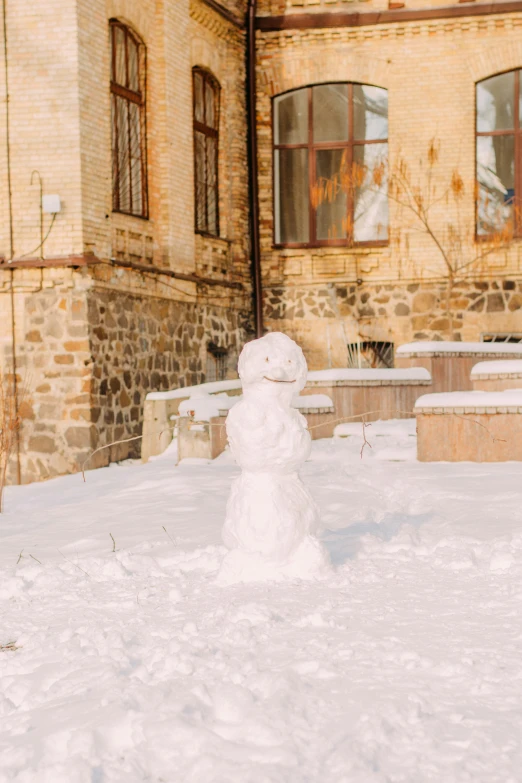 a snowman standing in the middle of a yard that is covered in white