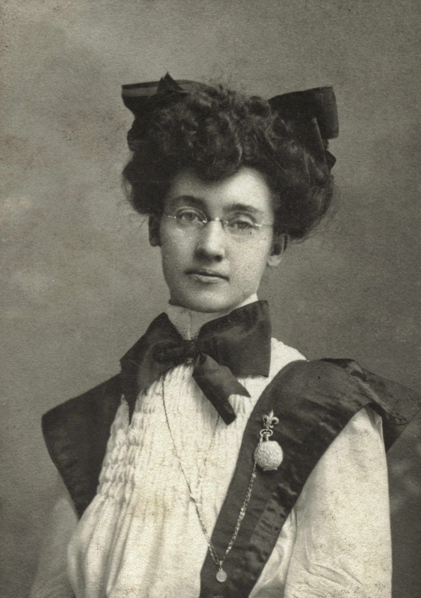 an old po of a woman wearing a vest and bow tie