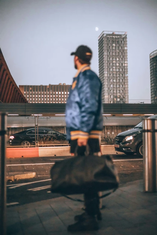 a man is walking down a city street holding a suitcase