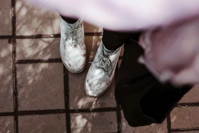 a person with their legs crossed and two shiny shoes