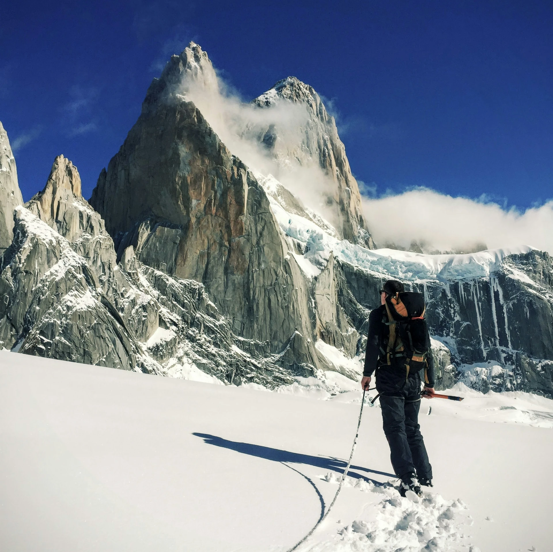 man cross country skiing in front of snow covered mountains