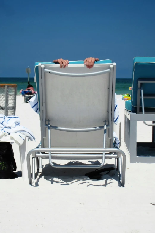 two chairs with a towel over them, facing the beach