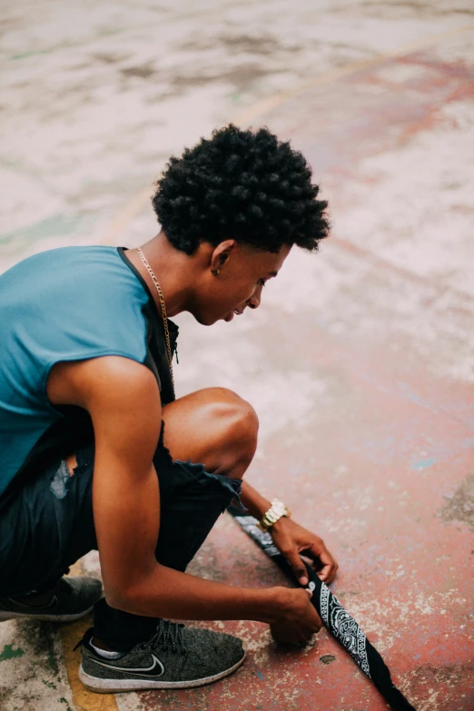 a man sits and holds onto the handle of a skateboard