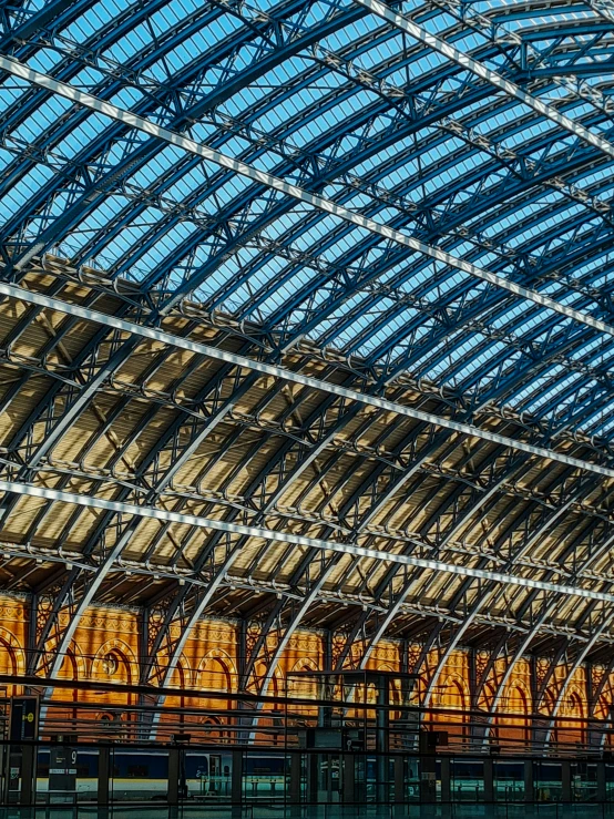 a glass roof is above an empty train station