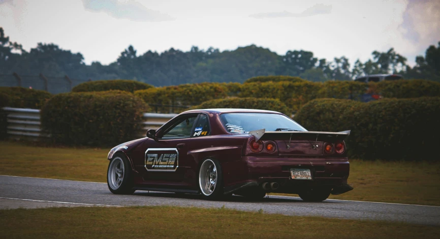 a car on a track in front of bushes