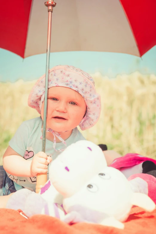 a little girl with an umbrella and stuffed animal
