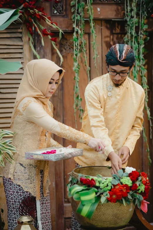 two people standing near each other  a cake together