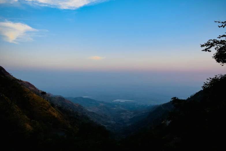 a view of mountains and a river during dusk