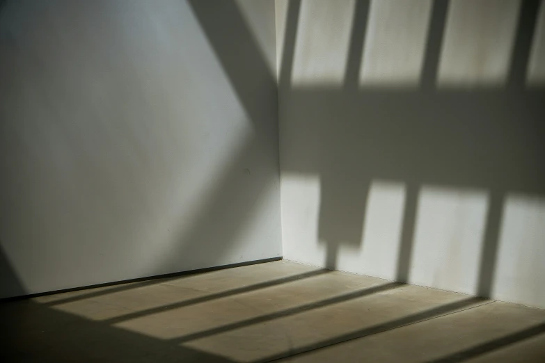 a small room with a wall and shadows on the walls