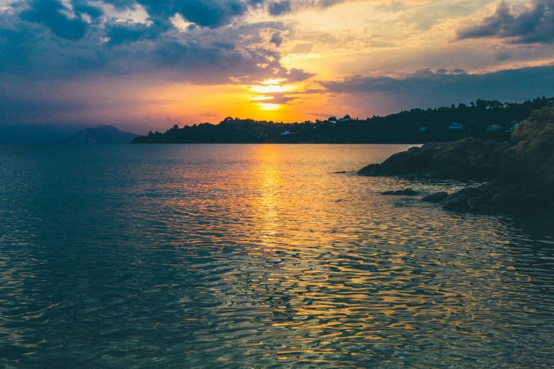 the water is very calm at sunset with a boat