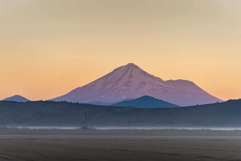 a horse is grazing in a pasture at sunrise