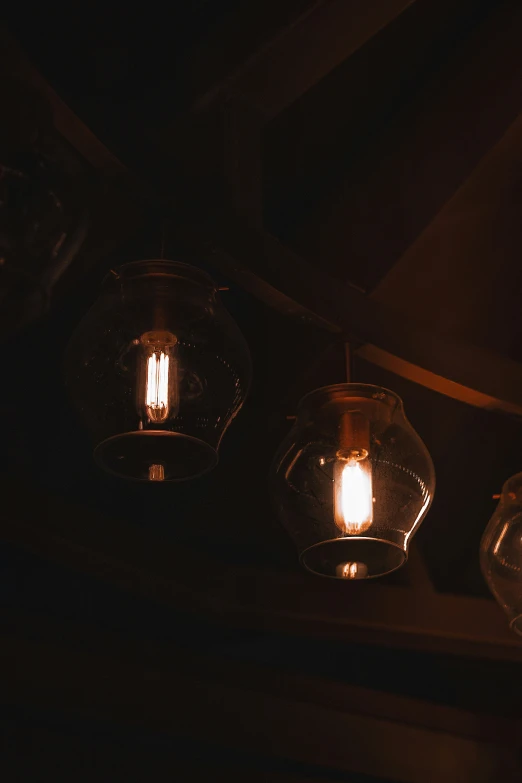 three small lights hanging from the ceiling in a dark room